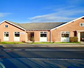 Basen Nord i Birkerød set fra gaden. En rød hesteskoformet bygning og blå hummel.